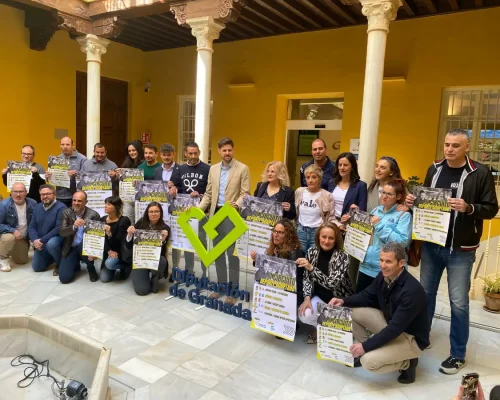 Organizadores y colaboradores del Circuito Deportivo Adaptado posan exhibiendo el cartel del evento, alrededor de un logotipo de Diputación de Granada.